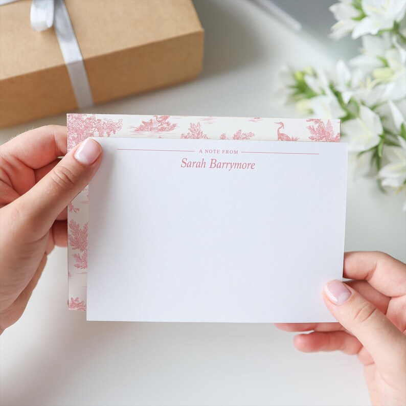 May include: A white note card with a pink floral border and the text "A note from Sarah Barrymore" printed on the top.