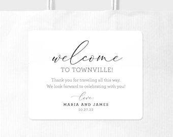 May include: A white welcome sign with black text that reads "welcome to Townville!"  Thank you for traveling all this way. We look forward to celebrating with you! love, Maria and James 10.27.23