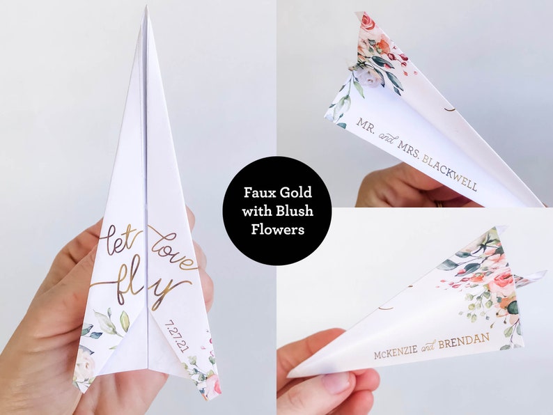 May include: White paper airplane with gold foil text that reads "let love fly" and "7.27.21". The airplane is decorated with blush-colored floral accents. The image also shows the names "Mr. and Mrs. Blackwell" and "McKenzie and Brendan".