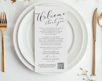 Puede incluir: Un lugar para una recepción de boda con una tarjeta blanca que dice "Bienvenida y Gracias" en una escritura elegante. La tarjeta está sobre un plato blanco, con cubiertos dorados y una ramita de flores. La tarjeta incluye un código QR.