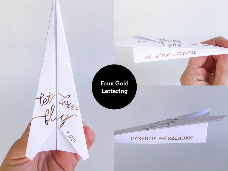 May include: White paper airplane with faux gold lettering that reads "let love fly" and the date "7.27.21". Additional airplanes feature names like "Mr. and Mrs. Blackwell" and "McKenzie and Brendan".