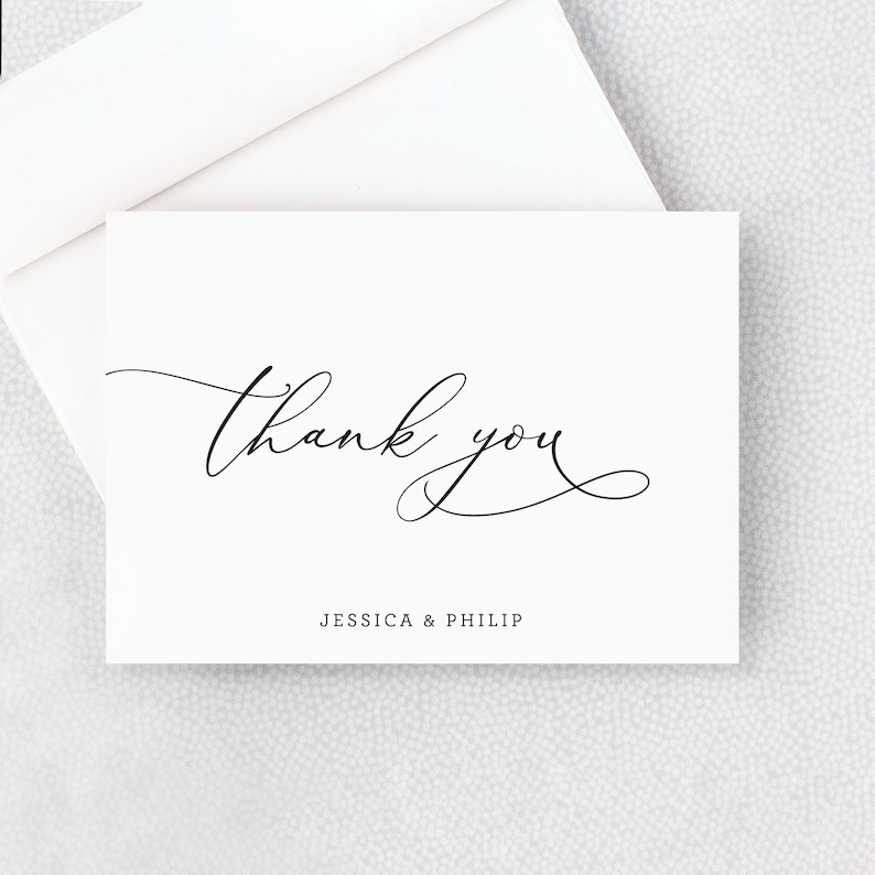 May include: White thank you card with black calligraphy that says "thank you" and the names "Jessica & Philip" printed below.