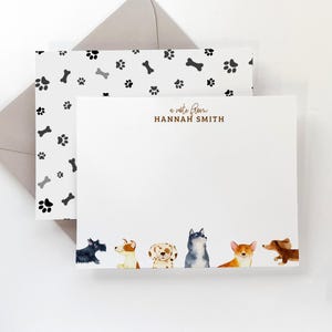 May include: A white card with a black and white paw print and bone pattern on the back. The front of the card has a brown border with the text "a note from HANNAH SMITH" and a row of watercolor illustrations of dogs at the bottom.