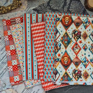 May include: A collection of cotton fabric sheets featuring circus-themed patterns including lions, elephants, clowns, monkeys, hot air balloons, and stars. The designs incorporate red, blue, and yellow diamonds, stripes, and polka dots on white.