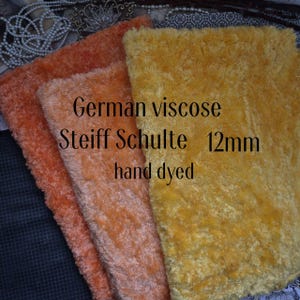 May include: Three pieces of hand-dyed German viscose Steiff Schulte fabric in shades of orange and yellow. The fabric is 12mm thick and has a soft, plush texture. The text "German viscose Steiff Schulte 12mm hand dyed" is visible.
