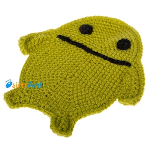 May include: Green crocheted plush toy shaped like an Android robot with black eyes and a black mouth.