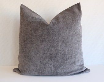 May include: A gray, textured throw pillow with a square shape.