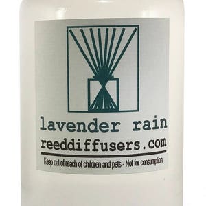 May include: A clear glass bottle with a white cap filled with a lavender scented reed diffuser oil. The label reads "lavender rain reeddiffusers.com" and "Keep out of reach of children and pets - Not for consumption."