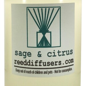 May include: A clear glass bottle with a white cap filled with a light yellow liquid. The bottle has a label with a green logo and the text "sage & citrus reeddiffusers.com". The label also includes the text "Keep out of reach of children and pets - Not for consumption."
