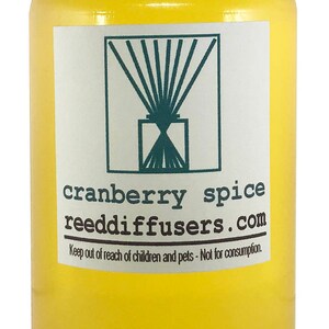 May include: A yellow glass bottle with a white lid filled with a clear liquid. The label reads "cranberry spice reeddiffusers.com" and "Keep out of reach of children and pets - Not for consumption."