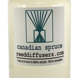 May include: A clear glass bottle with a white cap filled with a light yellow liquid. The label reads "canadian spruce reeddiffusers.com" and "Keep out of reach of children and pets - Not for consumption."