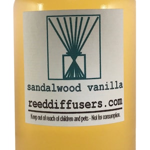 May include: A clear glass bottle with a white cap filled with a yellow liquid. The label reads "sandalwood vanilla reeddiffusers.com" and "Keep out of reach of children and pets - Not for consumption."