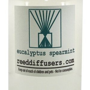May include: A clear glass bottle with a white lid and a label that reads "eucalyptus spearmint reeddiffusers.com". The label also includes the text "Keep out of reach of children and pets - Not for consumption."