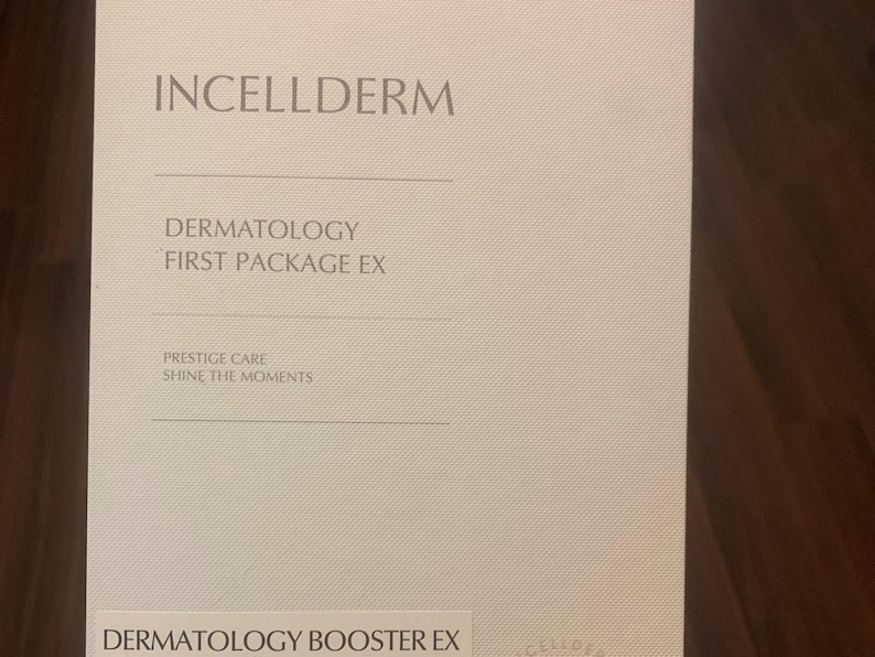Op de afbeelding: Een witte kaart met de tekst "INCELLDERM" in grote, vetgedrukte letters bovenaan. Onder de tekst bevindt zich een kleinere tekstbox met de woorden "DERMATOLOGY FIRST PACKAGE EX". Daaronder bevindt zich een andere tekstbox met de woorden "PRESTIGE CARE SHINE THE MOMENTS". Onderaan de kaart staat de tekst "DERMATOLOGY BOOSTER EX".