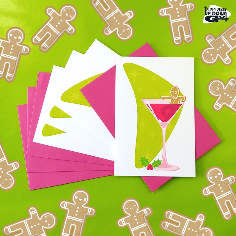May include: A set of five pink and white greeting cards with a green and white illustration of a gingerbread person in a martini glass. The text on the card reads "Pushy Pushy Up Down Go".