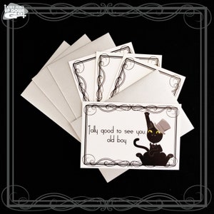May include: A set of five blank greeting cards with black and white decorative borders. The card on top features a black cat wearing a top hat and bow tie with the text "Jolly good to see you, old boy".