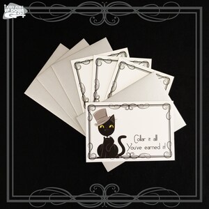 May include: Set of six blank greeting cards featuring a black cat wearing a top hat and bow tie. The cards have a black and white ornate border and the text "Collar it all You've earned it!"