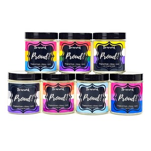 May include: Eight small glass jars with black lids and labels that say "Briarwick Proud!" with a rainbow flag design. The jars are filled with a white wax and are arranged in two rows of four. The jars are soy candles with a tropical fruit and citrus scent.