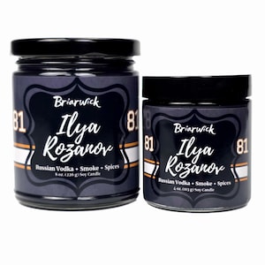 May include: Two black lidded glass jars of soy candles. The labels read "Briarwick Ilya Rozanov Russian Vodka + Smoke + Spices" with the candle sizes of 8 oz. (226 g) and 4 oz. (113 g). The labels are dark blue with white and orange accents.