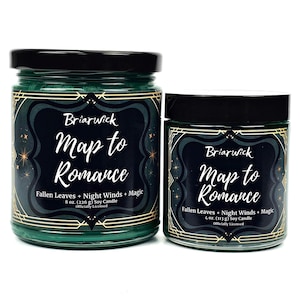 May include: Two green glass candle jars with gold accents and black lids. The jars are labeled "Briarwick Map to Romance" and feature the text "Fallen Leaves + Night Winds + Magic". The larger jar is 8 ounces and the smaller jar is 4 ounces.