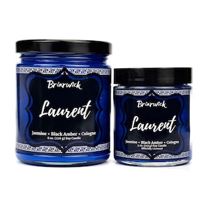 Puede incluir: Dos frascos de vidrio azul de velas de soja perfumadas con tapas negras. Las etiquetas dicen "Briarwick Laurent" con "Jasmine + Black Amber + Cologne" y el tamaño de la vela, 226 g y 113 g.