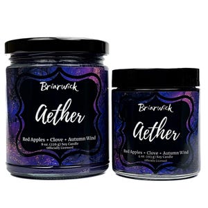 Könnte beinhalten: Zwei Gläser mit Sojakerzen und schwarzen Deckeln. Auf den Etiketten steht "Briarwick Aether" mit "Red Apples + Clove + Autumn Wind". Das größere Glas ist 226 g, das kleinere 113 g. Der Hintergrund ist eine Mischung aus Lila und Blau.