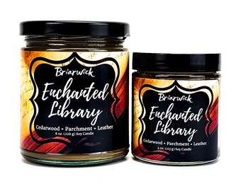 May include: Two soy candles in glass jars with black lids. The larger candle is 8 ounces and the smaller candle is 4 ounces. Both candles have a label that says "Briarwick Enchanted Library" and list the scent as "Cedarwood + Parchment + Leather".