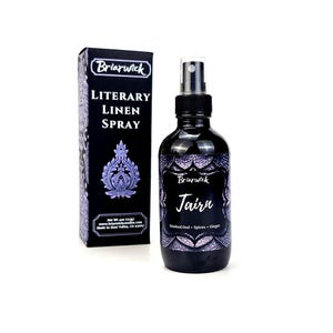 May include: A black bottle with a purple and silver label that reads "Briarwick Jairn Smoked Oud + Spices + Ginger" and a black box with a purple and silver label that reads "Briarwick LITERARY LINEN SPRAY".