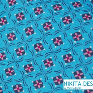 Könnte beinhalten: Ein türkisfarbener Stoff mit einem sich wiederholenden Muster aus rosa und dunkelblauen Quadraten. Der Stoff hat ein weißes Punktmuster und der Text "NIKITA DESIGN by Monika Bijen" ist in der rechten unteren Ecke aufgedruckt.