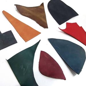 Puede incluir: Surtido de ocho recortes de cuero en varios colores, incluyendo marr&oacute;n, naranja, rojo, verde y azul. Las piezas de cuero est&aacute;n dispuestas en forma de estrella sobre una superficie blanca.