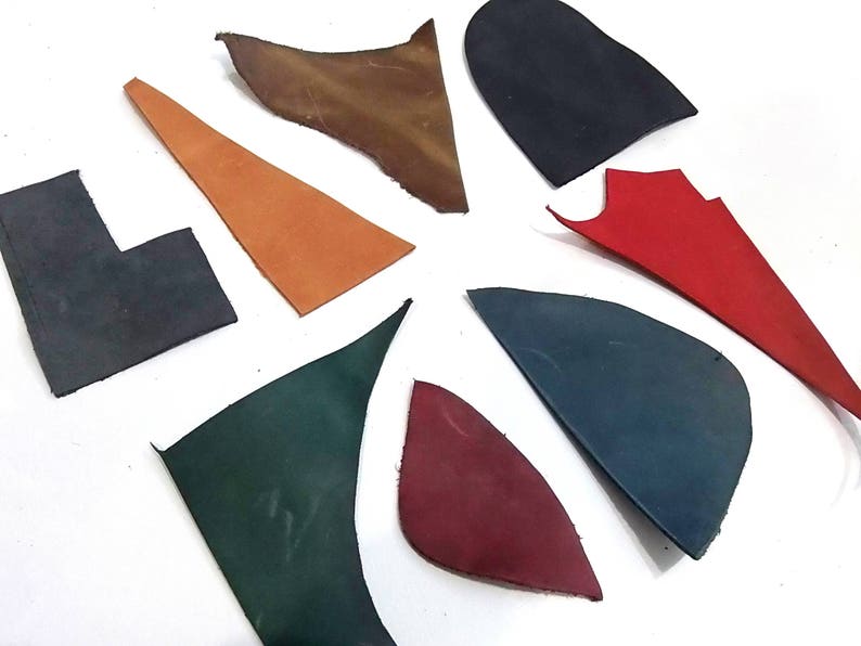 Puede incluir: Surtido de ocho recortes de cuero en varios colores, incluyendo marr&oacute;n, naranja, rojo, verde y azul. Las piezas de cuero est&aacute;n dispuestas en forma de estrella sobre una superficie blanca.