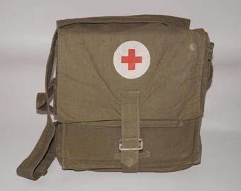 Borsa medica militare d'epoca per il pronto soccorso, anni '70-'80. Nessun contenuto all'interno. Tutto come in foto. Ruggine, macchie, abrasioni, strappi. Aspetto in foto.