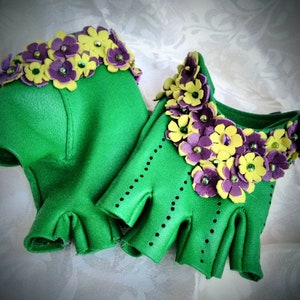 May include: A pair of green leather fingerless gloves with yellow and purple flower embellishments.