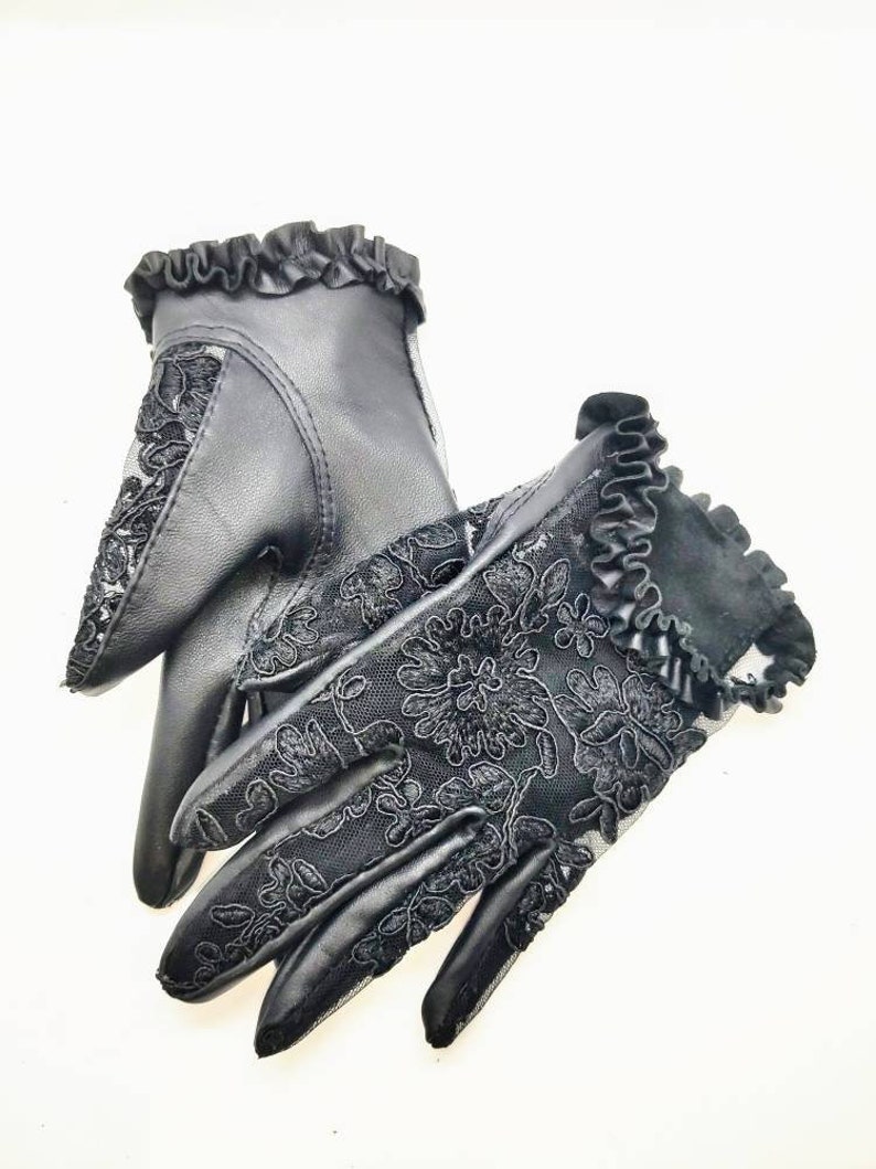 May include: A pair of black leather gloves with lace detailing and a ruffled trim.