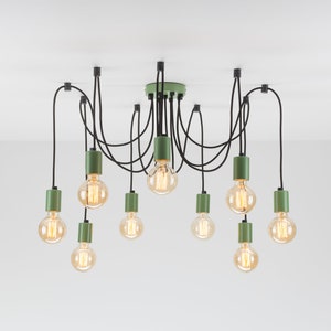 May include: A modern, multi-bulb ceiling light fixture. The fixture features ten Edison-style light bulbs suspended from black cords. The fixture has a green central mounting plate and green cylindrical accents. The light bulbs are lit with a warm, yellow glow.