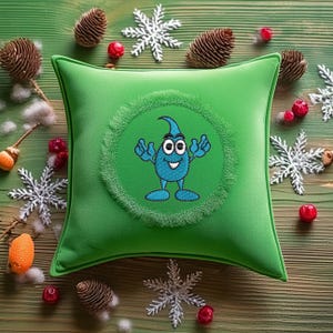 May include: Green throw pillow with a blue cartoon character embroidered on it. The character is a smiling water drop with arms and legs. The character is surrounded by a green circle with a fringe border.