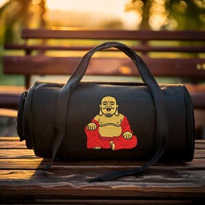 May include: Black duffel bag with a red and gold embroidered image of a smiling Buddha sitting in a meditative pose.