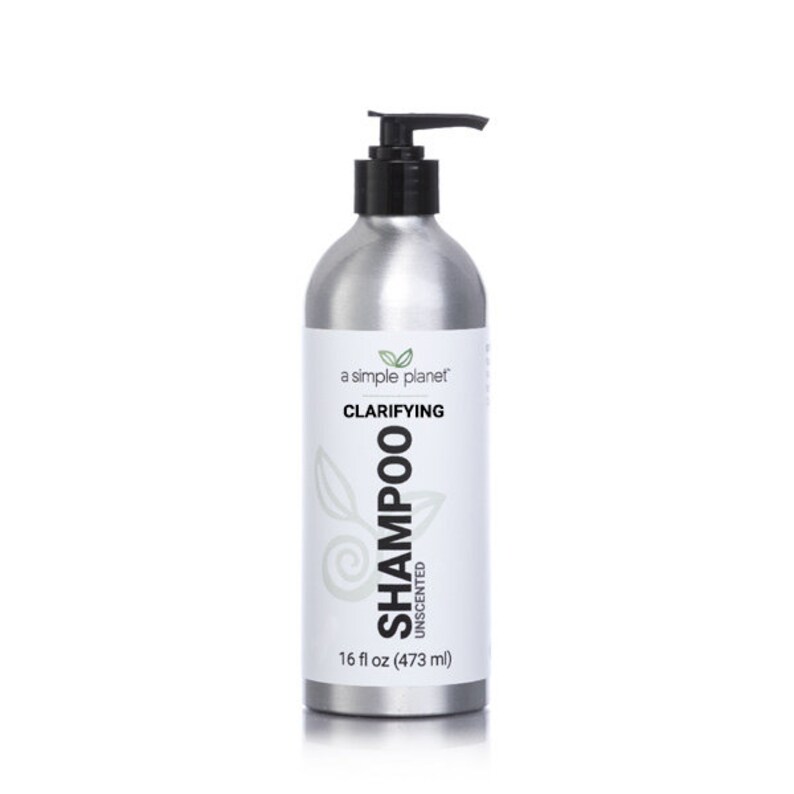 May include: A silver bottle of clarifying shampoo with a black pump top. The bottle is labeled "a simple planet" and "Clarifying Shampoo Unscented". The bottle contains 16 fl oz (473 ml).