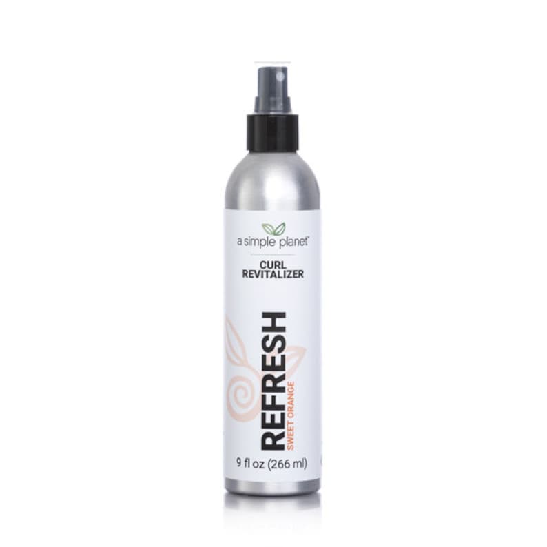 May include: A silver spray bottle with a black pump top and a white label that reads "a simple planet" and "CURL REVITALIZER". The label also features a green leaf logo and the text "REFRESH SWEET ORANGE" in a pink and orange color scheme. The bottle contains 9 fluid ounces (266 ml) of product.