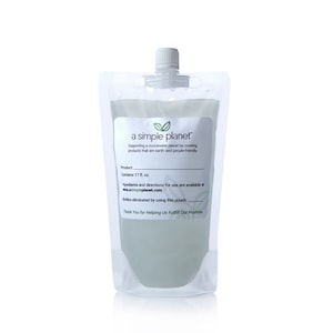 May include: A white, stand-up pouch with a clear, liquid-filled interior. The pouch has a white cap and a label that reads "a simple planet" with the tagline "Supporting a sustainable planet by creating products that are earth- and people-friendly." The label also states "Product Contains 17 fl. oz." and "Bottles eliminated by using this pouch: Thank You for Helping Us Fulfill Our Promise."