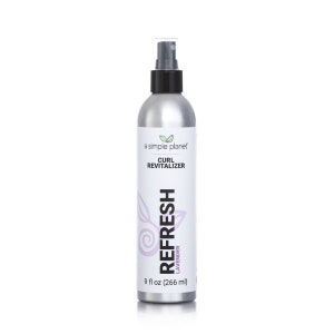 May include: A silver spray bottle with a black cap and a white label that says "a simple planet" and "CURL REVITALIZER". The label also has a purple design with the word "REFRESH" and "LAVENDER" in white text. The bottle contains 9 fl oz (266 ml) of product.