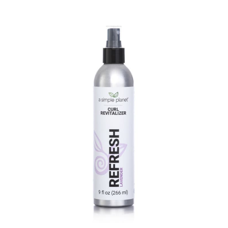 May include: A silver spray bottle with a black cap and a white label that says "a simple planet" and "CURL REVITALIZER". The label also has a purple design with the word "REFRESH" and "LAVENDER" in white text. The bottle contains 9 fl oz (266 ml) of product.
