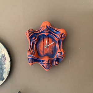 Orange & Blå väggklocka med 6 huvuden