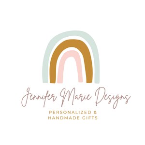 May include: A logo featuring a rainbow with pastel blue, brown, and pink colors. The text "Jennifer Marie Designs" is written in cursive below the rainbow. The text "Personalized & Handmade Gifts" is written in a smaller font below the cursive text.
