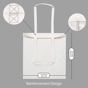May include: A white canvas tote bag with reinforced stitching and handles. The bag measures 15 inches wide and 16 inches tall.