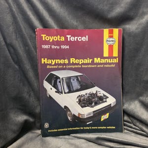 May include: A Haynes Repair Manual for the Toyota Tercel, covering the years 1987 through 1994. The cover features a white car with its hood open, and the Haynes logo in red and yellow.