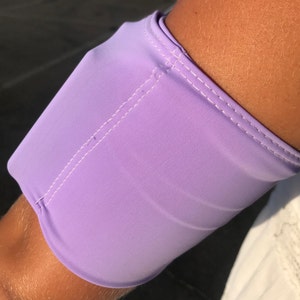 Pu&ograve; includere: Un braccialetto color lavanda con cuciture bianche. Il braccialetto &egrave; realizzato in un tessuto morbido ed elastico.