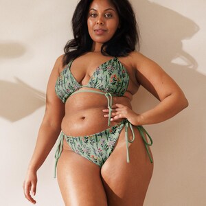 May include: A green floral print bikini with a triangle top and a high-cut bottom. The bikini has adjustable straps and ties at the sides.