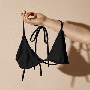May include: A black triangle bikini top with adjustable straps. The straps are tied at the neck and back.
