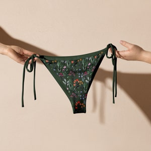 May include: Green bikini bottom with a floral print. The bikini bottom has adjustable ties on both sides.
